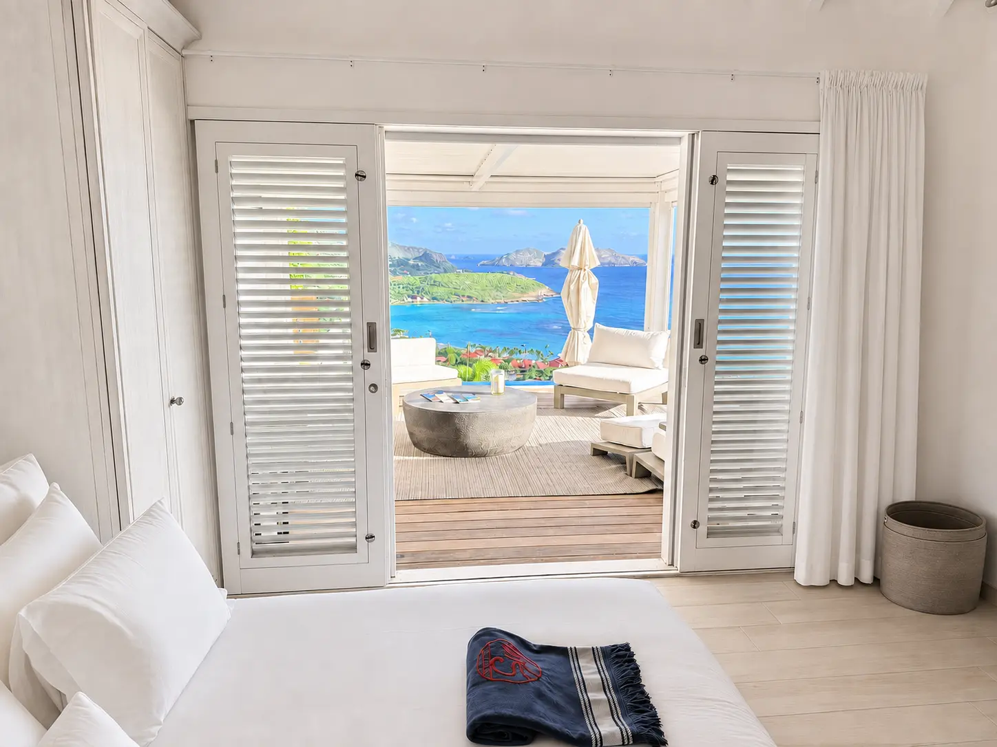 Bedroom suite with sliding doors open to a private terrace and ocean view