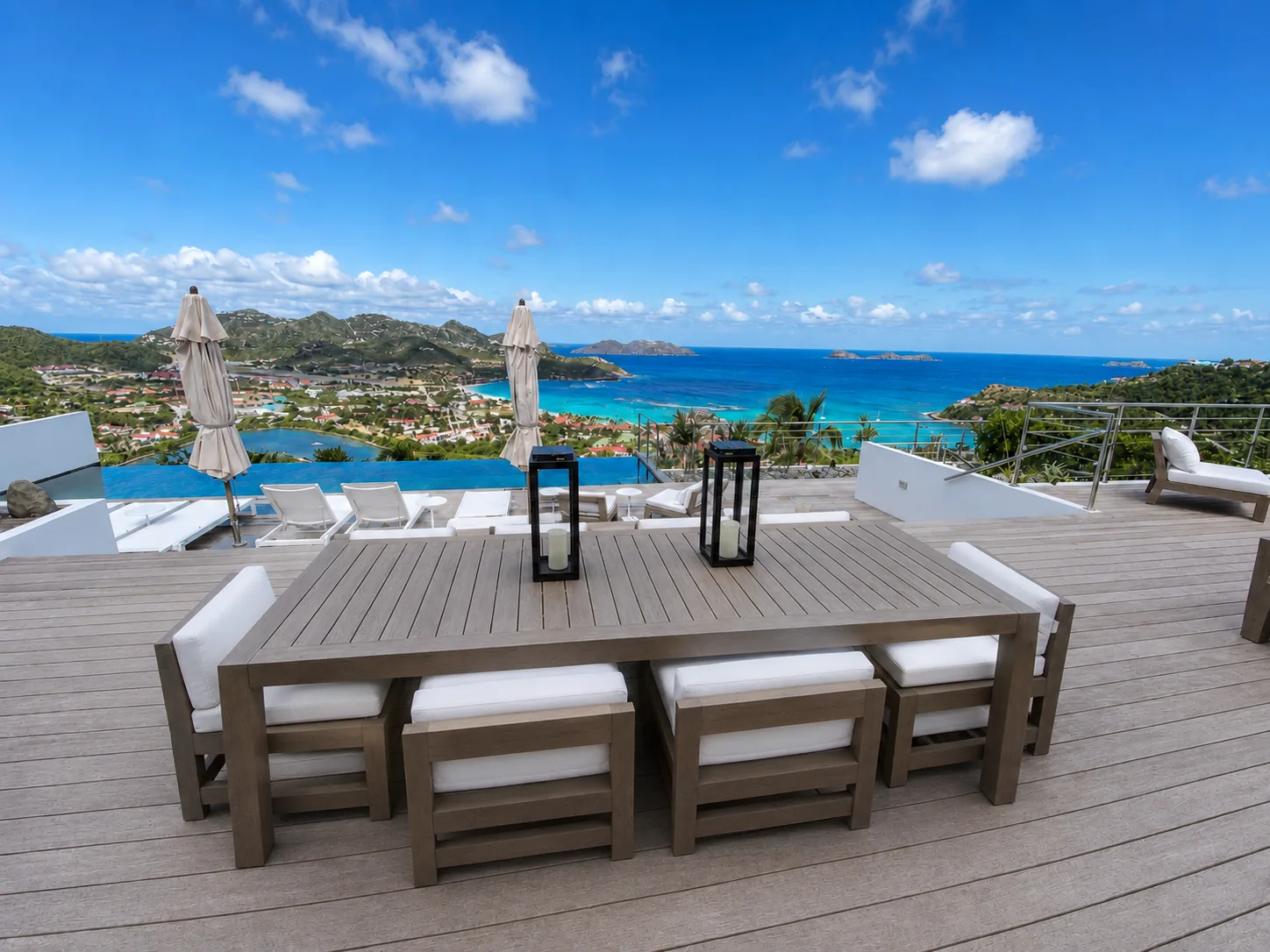 Outdoor dining table on the terrace with infinity pool and St. Jean Bay beyond